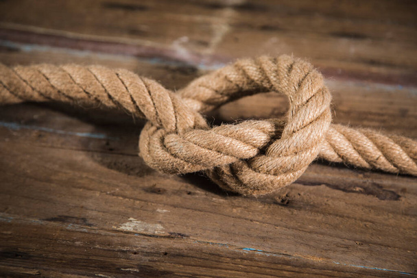 Nodo su una corda su uno sfondo di legno. - Foto, immagini