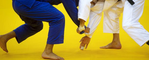 Two judo fighters in white and blue uniform. Professional sport concept - Фото, изображение