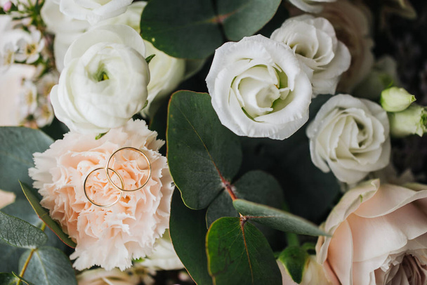 anillos de boda en hermosas flores en flor - Foto, Imagen