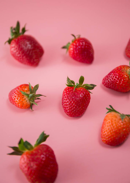 Köstliche saftige reife rote Erdbeeren auf rosa Hintergrund. Nahaufnahme von Erdbeeren auf einer Reibe. Beerenmuster - Foto, Bild
