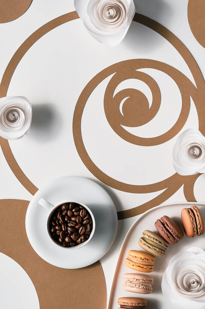 Coffee beans in cup, macarons, Fibonacci sequence circles. Espresso, tasty perfection. Golden ratio concept, paper art. Top view, flat lay in two tones, white and brown. Paper roses. - Φωτογραφία, εικόνα