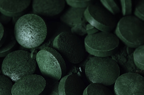 Spirulina powder and tablets algae. Macro close up.  - Fotó, kép