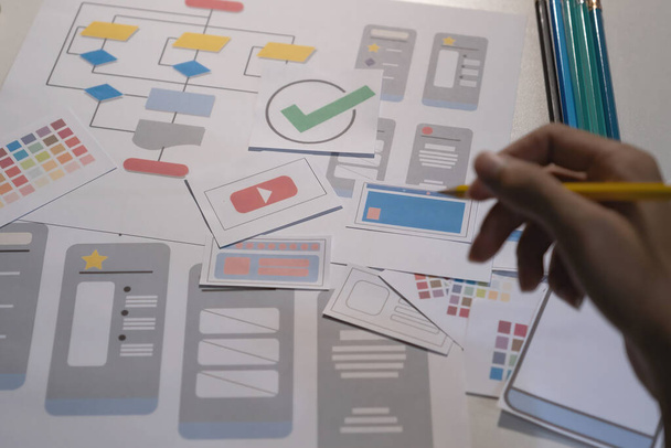 Designers desenho móvel conceito de desenvolvimento de aplicativos ux. Homem segurar lápis com mockup ui. - Foto, Imagem
