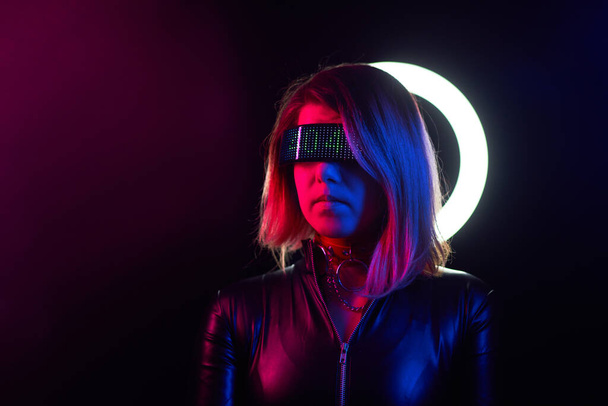 Cyberpunk style portrait of beautiful young woman in futuristic costume. - Фото, изображение