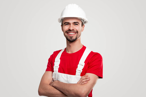 Friendly smiling builder in uniform looking at camera - Zdjęcie, obraz