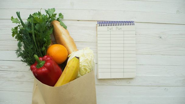 Lebensmittel mit leerem Notizbuch auf Holztisch - Foto, Bild