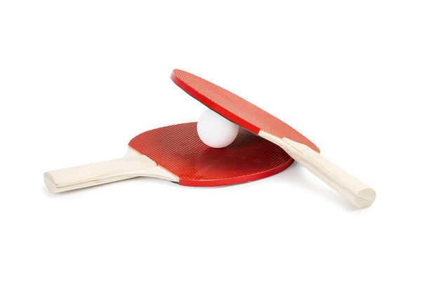 Δύο κόκκινα paddles πινγκ πονγκ και μια λευκή μπάλα σε λευκό φόντο - Φωτογραφία, εικόνα