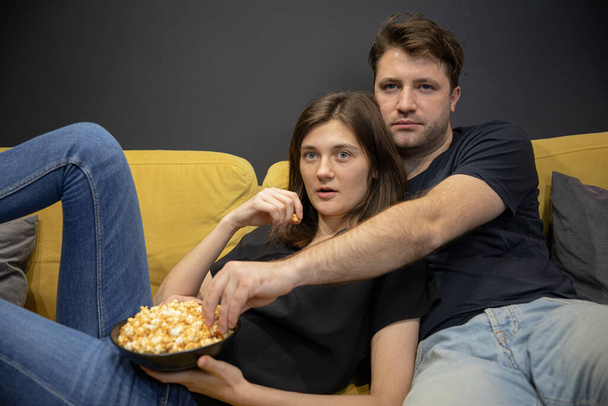 Couple watching tv love story, investigation, thriller hugging lying on couch - Fotoğraf, Görsel