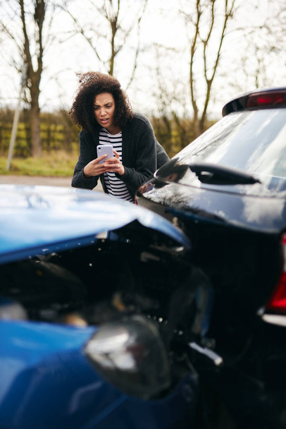 Kadın sürücü sigorta talebi için cep telefonuyla trafik kazasının fotoğraflarını çekiyor. - Fotoğraf, Görsel