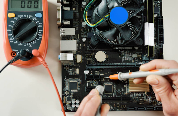 A technician checks the serviceability of the computer motherboard. - Photo, Image