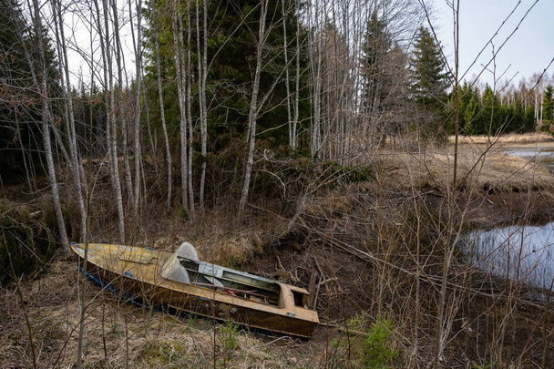 Starý rezavý kovový člun stojí na břehu rybníčku s nízkou hladinou vody - Fotografie, Obrázek