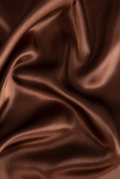 barna vagy csokoládé selyem selyem szövet textúra háttér.Ruha lágy hullám. Szaténkömény - Fotó, kép
