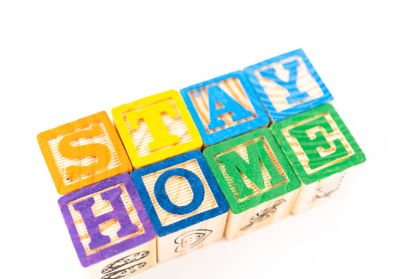 STAY HOME sign out of kids' alphabet blocks on a white background. - Photo, Image