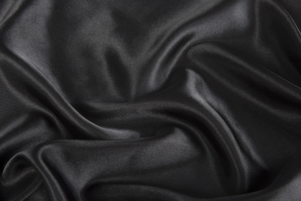 Abstract black silk fabric texture background. Cloth soft wave. Creases of satin - Фото, изображение