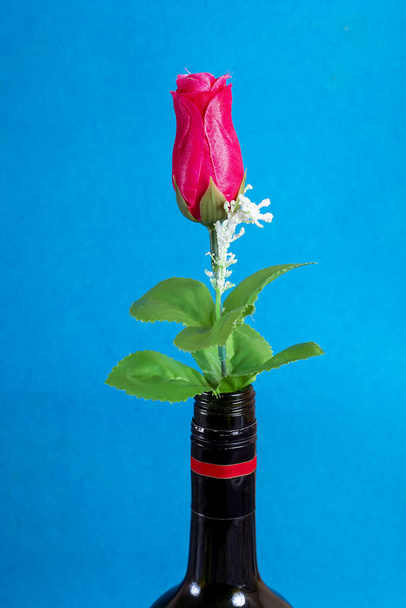 A closeup shot of a colorful artificial bouquet in a flowerpot on blue background - Zdjęcie, obraz