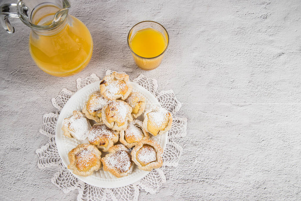 Верхний вид на завтрак с апельсиновым соком и традиционным португальским домашним слоеным тестом с яичным кремом. Десерт Pasteis de nata. - Фото, изображение