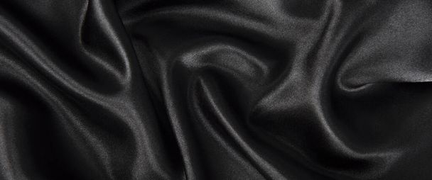 Abstract black silk fabric texture background. Cloth soft wave. Creases of satin - Foto, afbeelding