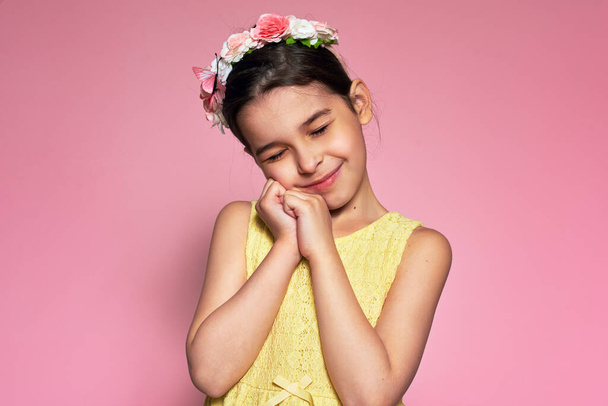 Adorable little girl smiling with closed eyes feeling joyful, isolated over studio pink background. The cute kid has a happy, dreamy, and thankful expression on her face. - Foto, imagen