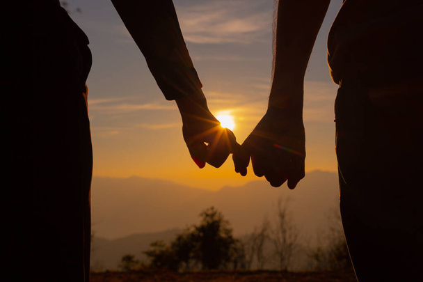Молода пара насолоджується заходом сонця в горі
 - Фото, зображення