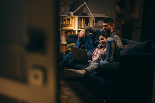 couple relaxing at home using laptop computer - Foto, Imagem