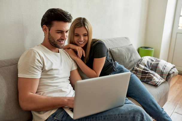 Young couple watching something funny on laptop and chilling - Foto, Bild