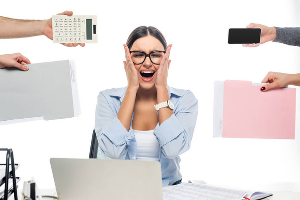 shocked businesswoman shouting with closed eyes at workplace near coworkers isolated on white - Фото, изображение