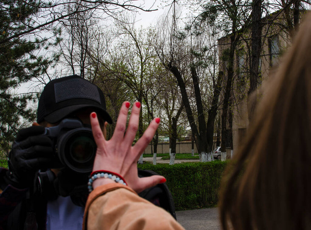 Το γυναικείο χέρι του διαδηλωτή καλύπτει τον φακό της κάμερας. Η έννοια της ισότητας των φύλων, φεμινίστριες. - Φωτογραφία, εικόνα