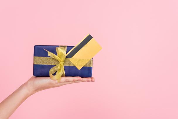cropped view of female hand with gift box and credit card isolated on pink - Foto, Imagem