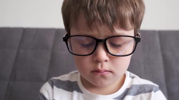 4k. mały słodkie biały chłopiec w okulary zbliżenie - Materiał filmowy, wideo