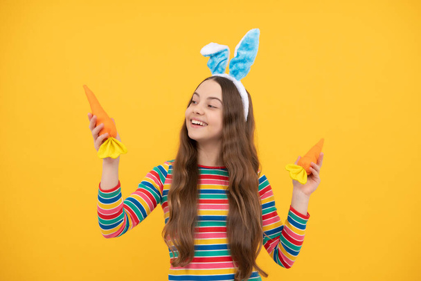 I want to eat. happy teen girl wear bunny ears. happy easter. childhood happiness. child in rabbit ears hold carrot. time for fun. adorable funny kid with carrot. easter spring holiday. - Fotó, kép