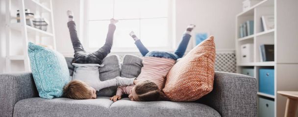 Cute children lying face down on the sofa - Photo, Image