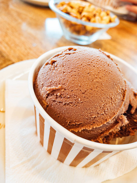 Scoop of chocolate ice cream in a tub - Foto, afbeelding