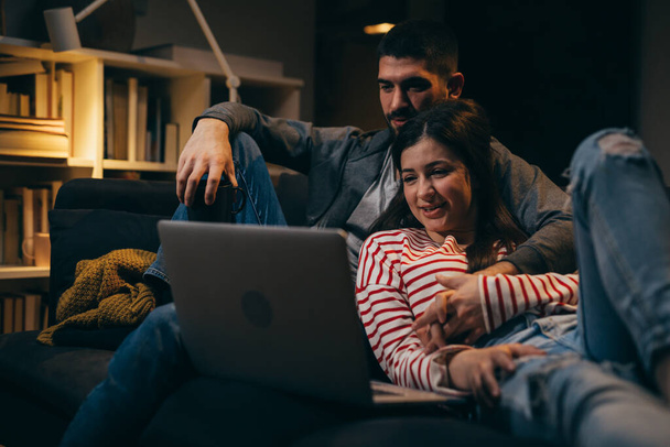 couple relaxing at home using laptop computer - Photo, image