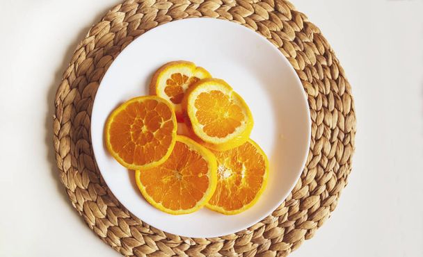 Seramik tabakta taze dilimlenmiş portakallar. Sığ bir alan derinliğine sahip bir makro.. - Fotoğraf, Görsel