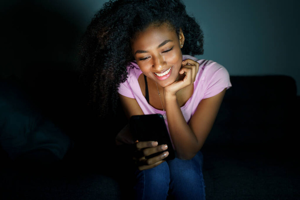 Frau nutzt nachts Smartphone. Gesicht wird mit Bildschirmlicht beleuchtet - Foto, Bild