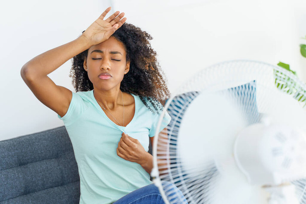 Jeune femme noire souffrant d'une vague de chaleur à la maison - Photo, image