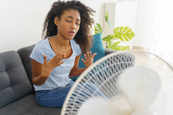 Black young woman suffering a heat wave at home - Photo, Image