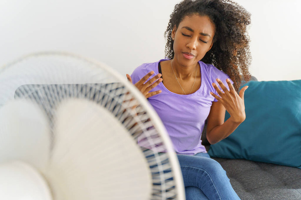 Black young woman suffering a heat wave at home - Foto, imagen
