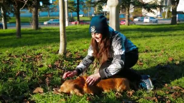 Young girl stroking her dog outdoors - Filmagem, Vídeo