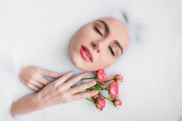 top view of young woman with pink roses taking milky bath - Fotografie, Obrázek