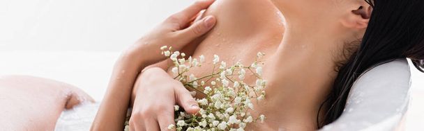 partial view of woman with white flowers enjoying milk bath, banner - Foto, Imagem
