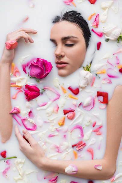 femme sensuelle prenant un bain avec du lait et des pétales de rose - Photo, image