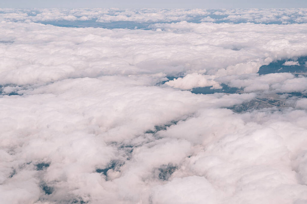 Вид из окна самолета на белые кучевые облака в небе - Фото, изображение