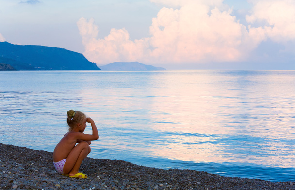 Sunset, shining sea surface and girl on beach - Фото, зображення