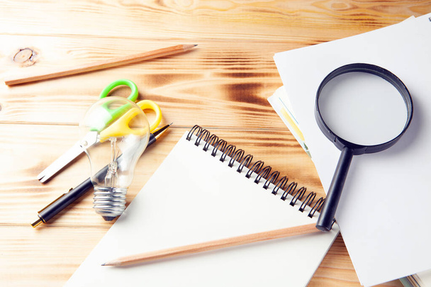 Concepto idea de estudio. lupa, bloc de notas, lámpara y pluma en el escritorio - Foto, imagen