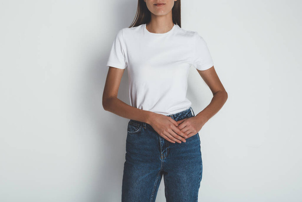 Ritratto ritagliato di giovane donna in jeans e t-shirt bianca bianca - Foto, immagini