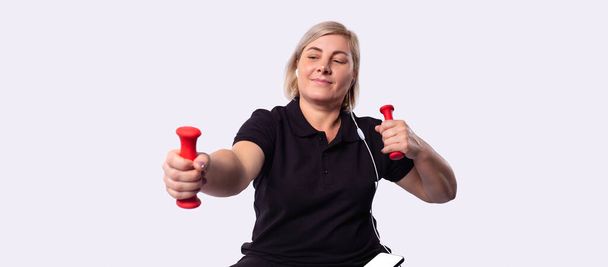 Attractive 50 year old woman doing fitness, isolated on gray background. High quality photo - Φωτογραφία, εικόνα