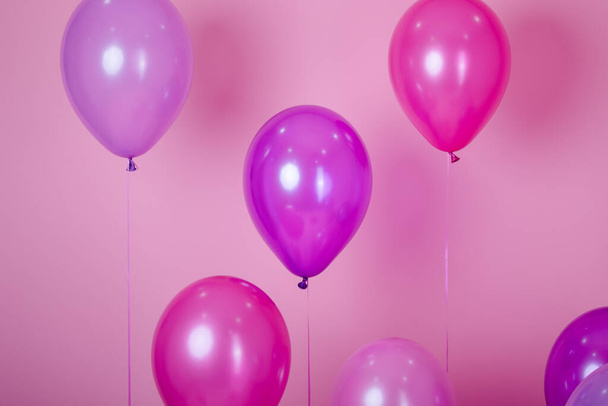 floating Colorful pink party balloons on pink pastel background. Space for text. Minimal idea creative concept of happiness, joy, birthday. holiday web banner with copy space. - Fotoğraf, Görsel