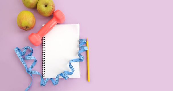 notebook, meetlint, appel op een gekleurde achtergrond - Foto, afbeelding