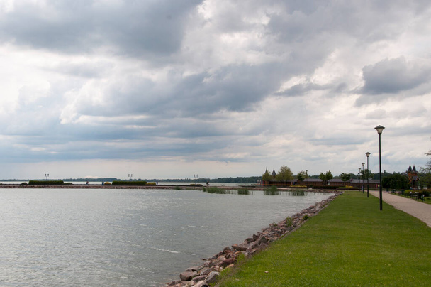 Panoramic view of the embankment with green lawns and the calm surface of Lake Balaton. - Photo, Image